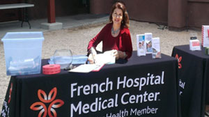 Mara Purl signs copies of her novels that were presented as gifts from French Hospital to guests at the event.